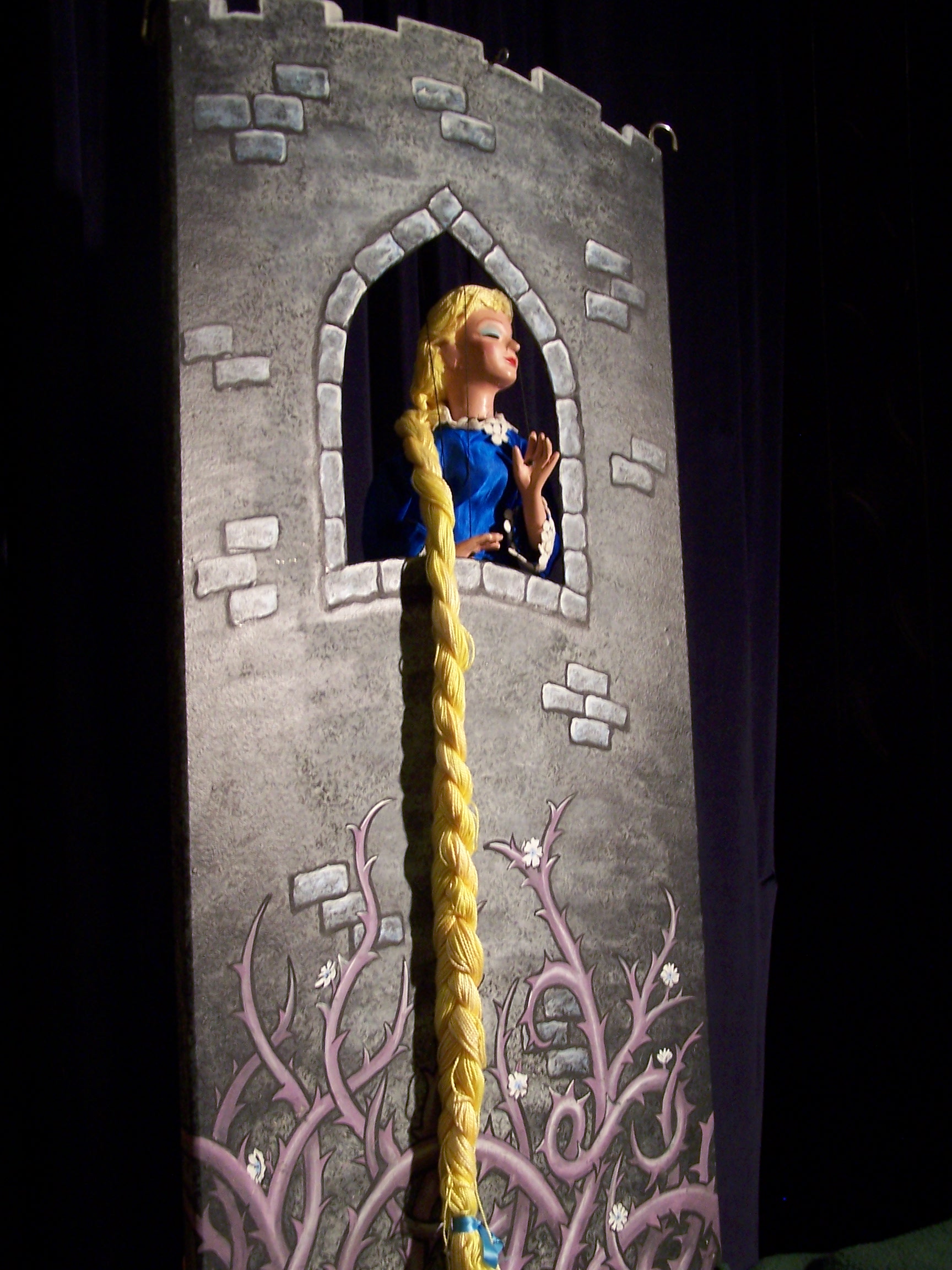 A cartoon of Rapunzel's long hair hanging out of a window in a tower A cartoon of Rapunzel's long hair hanging out of a window in a tower